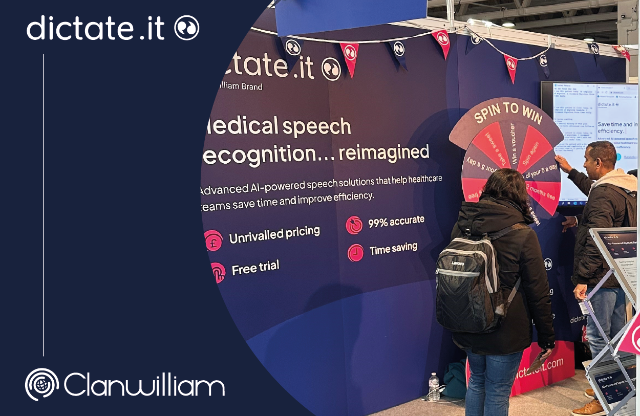 Dictate.IT's stand at Best Practice London, featuring navy blue and pink graphics, a 'spin to win' game and a TV.